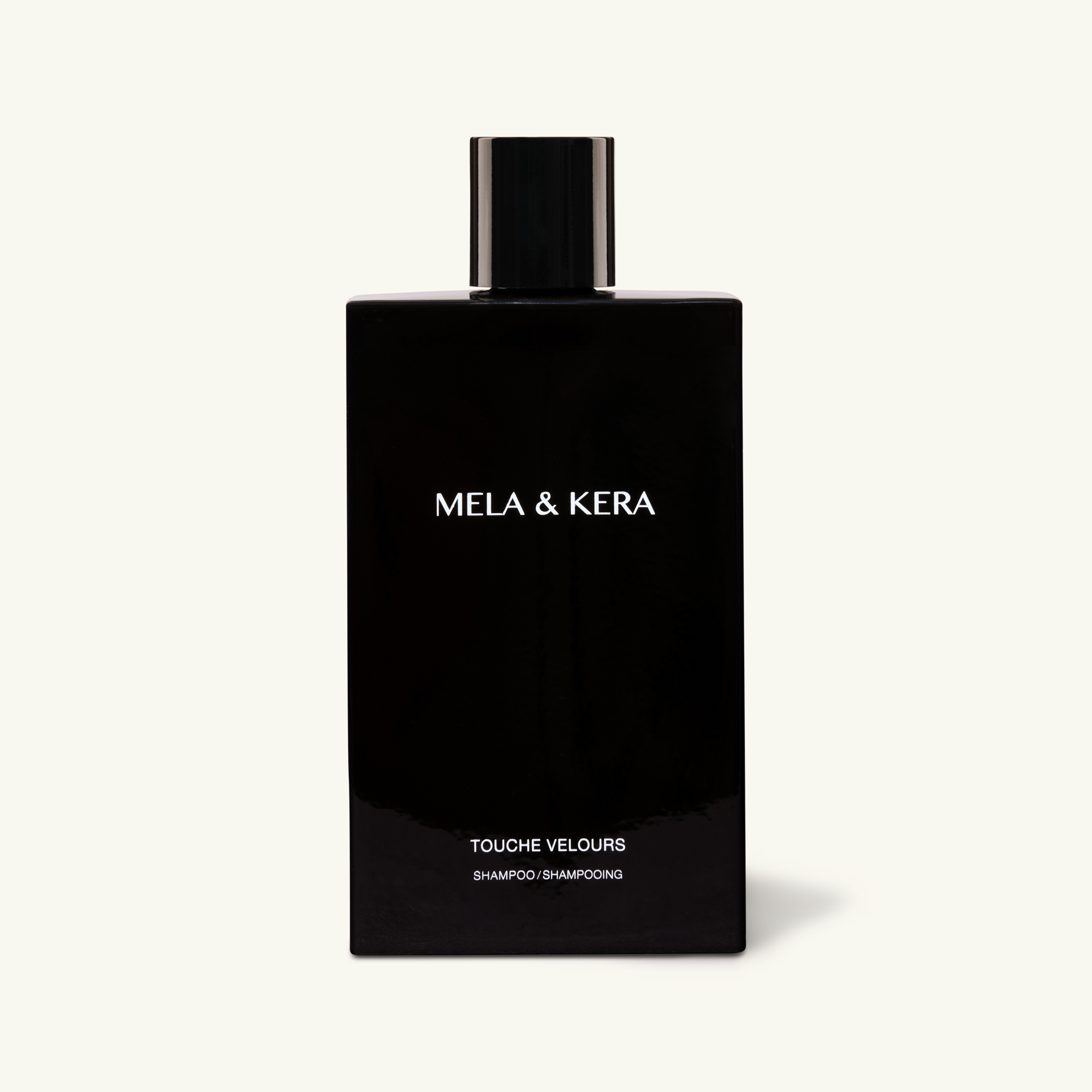 Mela & Kera black Touche Velours shampoo bottle on a white background