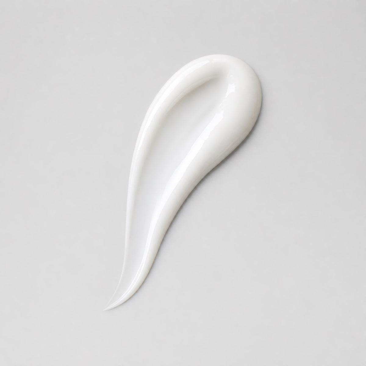White cream swatch with glossy curved smear